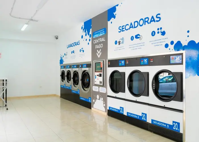 Intérieur de la Lavandería Azul d'El Fraile avec la borne de paiement centrale